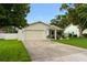 Charming single-story home featuring a two-car garage and well-maintained landscaping at 1562 Coastal Pl, Dunedin, FL 34698
