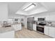 Bright kitchen features stainless steel appliances, granite countertops, and white cabinetry offering a clean and modern look at 1562 Coastal Pl, Dunedin, FL 34698