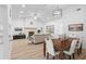 Open concept living and dining area featuring a stone fireplace, light plank flooring, and neutral decor at 1562 Coastal Pl, Dunedin, FL 34698