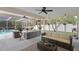 Spacious patio featuring comfortable seating, ceiling fans, and serene backyard views at 1562 Coastal Pl, Dunedin, FL 34698