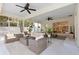 Inviting patio with cozy seating, ceiling fans, and access to the backyard at 1562 Coastal Pl, Dunedin, FL 34698