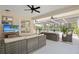 Relaxing covered patio with comfortable seating, ceiling fans, and a view of the pool at 1562 Coastal Pl, Dunedin, FL 34698