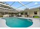 Beautiful backyard pool with covered lanai area, bar, seating, and well maintained patio at 1562 Coastal Pl, Dunedin, FL 34698