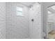 Modern walk-in shower with subway tile, a rainfall shower head, and a window for natural light at 1562 Coastal Pl, Dunedin, FL 34698