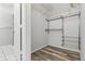 Walk-in closet featuring built-in shelves and wood-look flooring at 16109 Rambling Vine E Dr, Tampa, FL 33624
