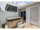 Enclosed patio featuring a hot tub, tile flooring, white privacy fence, and direct access to the home at 16109 Rambling Vine E Dr, Tampa, FL 33624