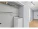 Convenient laundry area with a Whirlpool washer, storage shelves, and bright lighting near the entrance at 16109 Rambling Vine E Dr, Tampa, FL 33624