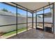 Enclosed patio featuring tiled flooring, a black metal enclosure, outdoor furniture, and view to the fenced backyard at 16109 Rambling Vine E Dr, Tampa, FL 33624