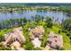 Stunning aerial view featuring a lakeside estate, a sparkling pool, lush landscaping, and beautiful neighboring properties at 17301 Ladera Estates Blvd, Lutz, FL 33548