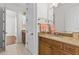 Bathroom featuring double sinks with granite countertops, wood cabinetry, a large mirror, and neutral tile flooring at 17301 Ladera Estates Blvd, Lutz, FL 33548