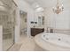 Elegant bathroom featuring a glass shower, soaking tub, and chandelier at 17301 Ladera Estates Blvd, Lutz, FL 33548