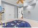 Bedroom featuring a large closet, blue walls, neutral carpet, and a ceiling fan at 17301 Ladera Estates Blvd, Lutz, FL 33548