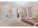 Charming bedroom features soft pink tones, plush carpeting, a chandelier, and balcony access at 17301 Ladera Estates Blvd, Lutz, FL 33548