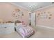Charming bedroom with pink walls, white trim, plush carpet, a chandelier, and a decorative flower display at 17301 Ladera Estates Blvd, Lutz, FL 33548