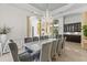 Bright dining area features a modern chandelier, and ten comfortable gray upholstered chairs at 17301 Ladera Estates Blvd, Lutz, FL 33548