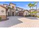 Charming home featuring a brick driveway, well-kept lawn, palm trees, and a stone-accented entrance and garages at 17301 Ladera Estates Blvd, Lutz, FL 33548