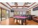 Expansive game room features a pool table, bar, beamed ceilings, and outdoor balcony access at 17301 Ladera Estates Blvd, Lutz, FL 33548