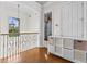 Second floor hallway with hardwood floors, iron railing, storage, and elegant lighting at 17301 Ladera Estates Blvd, Lutz, FL 33548