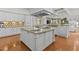 Open kitchen with a center island, granite countertops, and custom cabinetry overlooks the living space at 17301 Ladera Estates Blvd, Lutz, FL 33548