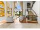 Spacious living room featuring tall ceilings, large windows, a fireplace, and staircase to the upper level at 17301 Ladera Estates Blvd, Lutz, FL 33548
