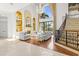 Bright, open living space with soaring ceilings, a fireplace, grand windows, and an elegant staircase at 17301 Ladera Estates Blvd, Lutz, FL 33548