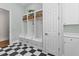 Organized mudroom with storage cubbies, drawers, and a black and white checkerboard floor at 17301 Ladera Estates Blvd, Lutz, FL 33548