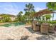 Enjoy the beautiful outdoor space with a pool, dining area, and lush landscaping with palm trees at 17301 Ladera Estates Blvd, Lutz, FL 33548