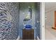 Unique powder room with mosaic walls, a decorative mirror, and custom vanity at 17301 Ladera Estates Blvd, Lutz, FL 33548