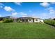Spacious backyard featuring a well-manicured lawn, vibrant landscaping, and a screened-in lanai for outdoor enjoyment at 180 Rotonda N Blvd, Rotonda West, FL 33947