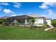 Large, well-maintained backyard featuring a screened-in pool, lush landscaping, and a paved walkway at 180 Rotonda N Blvd, Rotonda West, FL 33947