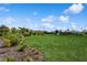Spacious backyard featuring lush green grass, tropical landscaping, and well-manicured garden beds at 180 Rotonda N Blvd, Rotonda West, FL 33947