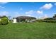 Lush backyard showcases a screened-in lanai, manicured lawn, and tropical landscaping for a serene outdoor setting at 180 Rotonda N Blvd, Rotonda West, FL 33947