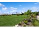 Expansive backyard with vibrant green lawn, carefully arranged tropical plants, and manicured landscaping at 180 Rotonda N Blvd, Rotonda West, FL 33947