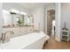 Bright bathroom featuring a soaking tub and white vanity with double sinks and marble countertops at 180 Rotonda N Blvd, Rotonda West, FL 33947