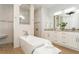 Bright bathroom featuring a soaking tub, walk-in shower, and white vanity with double sinks at 180 Rotonda N Blvd, Rotonda West, FL 33947