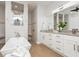 Bright bathroom featuring a soaking tub, walk-in shower, and white vanity with double sinks at 180 Rotonda N Blvd, Rotonda West, FL 33947