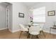 Bright dining area features modern light fixture, round glass table with white chairs at 180 Rotonda N Blvd, Rotonda West, FL 33947
