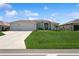 Charming single Gathering home with a lush green lawn, three-car garage, and beautiful landscaping at 180 Rotonda N Blvd, Rotonda West, FL 33947