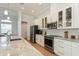Bright kitchen with stainless steel appliances, white cabinets, and a spacious countertop at 180 Rotonda N Blvd, Rotonda West, FL 33947