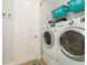 Functional laundry room featuring modern washer and dryer units, shelving, and ample space at 180 Rotonda N Blvd, Rotonda West, FL 33947