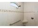 Walk-in shower featuring a built-in bench, hand rail, and mosaic tile accents at 180 Rotonda N Blvd, Rotonda West, FL 33947