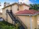 Here is the exterior of this two-story home with a metal staircase and a red tile roof at 18258 Wayne Rd, Odessa, FL 33556