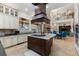 Spacious kitchen with custom cabinets, a center island cooktop, and views of the great room at 18258 Wayne Rd, Odessa, FL 33556