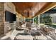 Luxurious covered patio with stone fireplace, outdoor kitchen, and comfortable seating area overlooking pool at 18258 Wayne Rd, Odessa, FL 33556