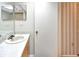 Well-lit bathroom featuring a single vanity, framed mirror, and stylish striped wallpaper at 2593 Countryside Blvd # 7305, Clearwater, FL 33761