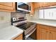 Kitchen featuring modern stainless steel appliances and light countertops with wooden cabinetry at 2593 Countryside Blvd # 7305, Clearwater, FL 33761
