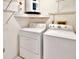 Functional laundry room equipped with a washer, dryer, and shelving for storage at 2593 Countryside Blvd # 7305, Clearwater, FL 33761