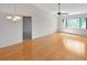 Living room with wood floors, a ceiling fan, chandelier, and a large window providing ample natural light at 2593 Countryside Blvd # 7305, Clearwater, FL 33761