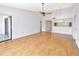 Bright living room features wood-look floors, ceiling fan, slider to balcony, and partial view of kitchen at 2593 Countryside Blvd # 7305, Clearwater, FL 33761