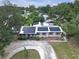 Aerial view of a single-story home featuring solar panels and circular driveway amidst lush trees at 2704 Dorene Dr, Plant City, FL 33563